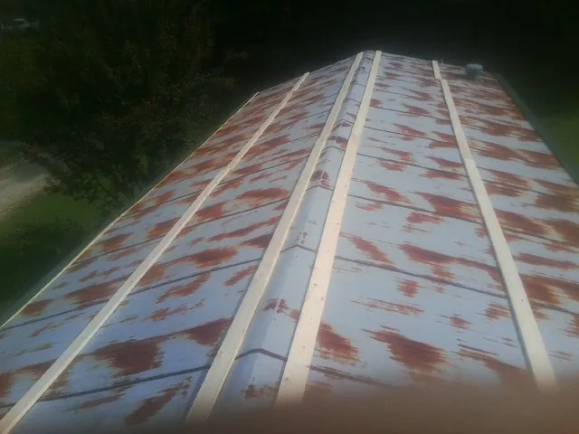 Rusted metal roof panels with new wood purlins before replacement — Storm Damage Roof Repair in Justice by Roofing Brothers