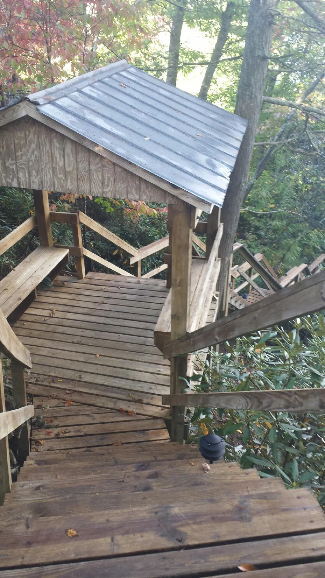 Metal roofed shelter over wooden steps on a wooded walkway — Skylight Repair & Installation work by our crew in Justice
